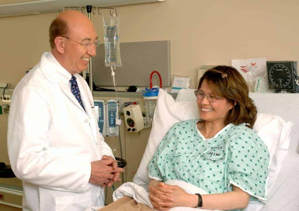 Arzt neben Frau im Krankenbett